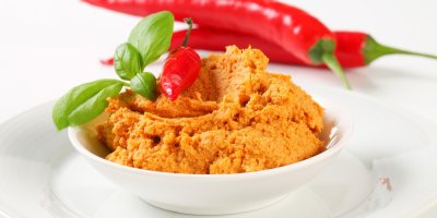 Budapešťská pomazánka na talířku a za ní chilli papričky