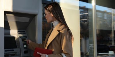 Žena vkládá kartu do bankomatu