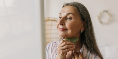 Žena používá masážítko gua sha