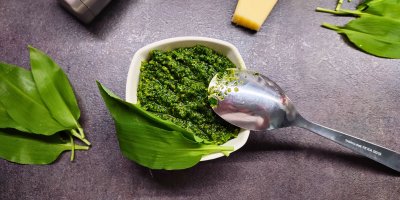 Pesto z medvědího česneku v malé bílé misce