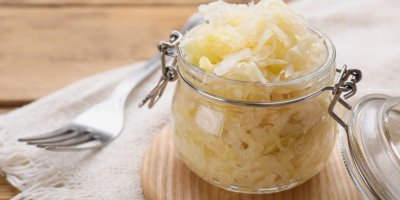 Sklenička s kysaným zelím, položená na dřevěném prkénku