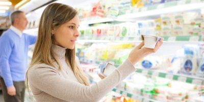 Žena vybírá jogurt v supermarketu