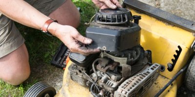 Muž opravuje zahradní sekačku