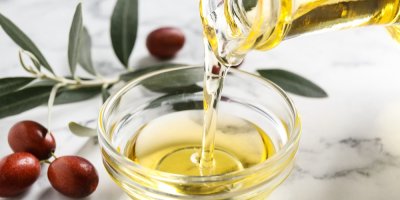 Jojobový olej litý do misky a plody jojoby