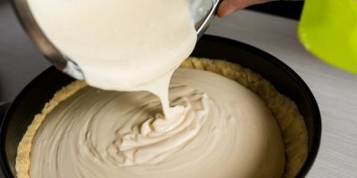 Příprava cheesecaku – nalévání sýrové náplně do formy