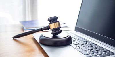 Aukční kladívko položené na laptovu