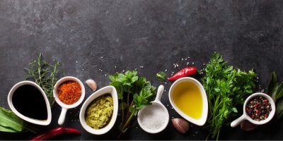 Bylinky, koření, olej, ocet, sůl na tmavém pozadí