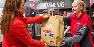 Prodavačky řetězce PENNY předává tašku s potravinami, objednanou na platformě Nesnězeno