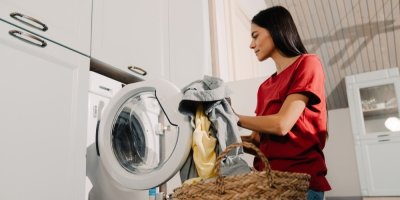 Žena v červeném triku plní pračku