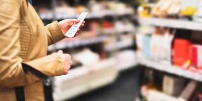 Žena nakupuje a dívá se na nákupní seznam