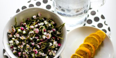 Sedmikrásky v misce, vedle nakrájený citron