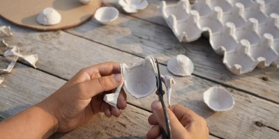 Člověk stříhá plato od vajec