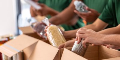 Lidé dávají do krabic potraviny