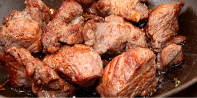 Kousky hovězího masa v pekáči s červeným vínem