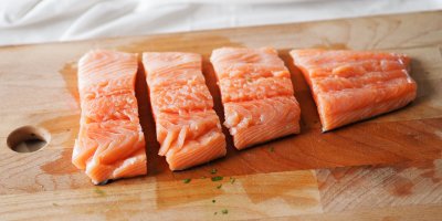 Rozporcovaný losos na dřevěném prkénku