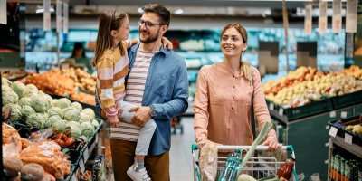 Šťastní rodiče s dcerkou nakupují v supermarketu