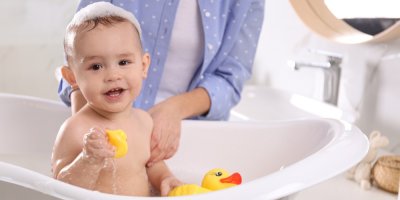 Dítě se koupe ve vaničce s kachničkou