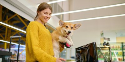 Žena je se psem v náručí v obchodě