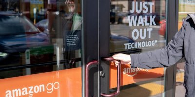 Muž otevírá skleněné dveře obchodu Amazon Go se sloganem Just Walk Out. Everett, USA – 25. března 2024