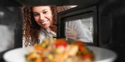 Žena otevírá mikrovlnku