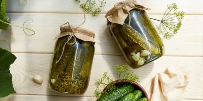 2 sklenice nakládaných okurek, položené na stole