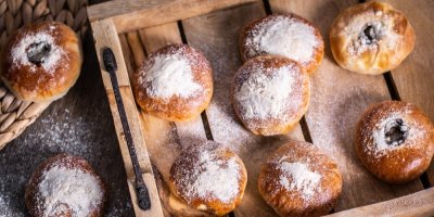 7 pocukrovaných koblih na dřevěném tácu