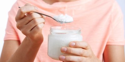 Lžíce s nabraným kokosovým olejem ze sklenice