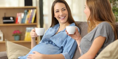 Těhotná žena popíjí kávu s přítelkyní