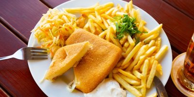 Smažený sýr s hranolky a tatarkou, servírovaný na bílém talíři