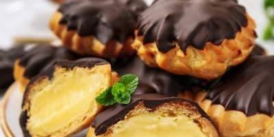 Několik profiterolek na talíři s čokoládovou polevou