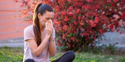 Žena sedí venku a smrká