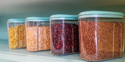 Čtyři velké vzduchotěsné nádoby, ve kterých jsou těstoviny, fazole, čočka a pohanka