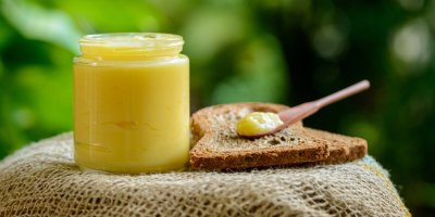 Ghee ve sklenici a vedle lžíce s toastem