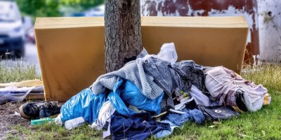Vyřazené oblečení vyhozené ke kontejneru na směsný odpad