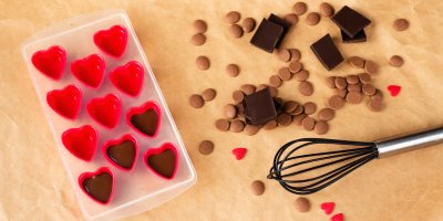 Formičky ve tvaru srdce, kousky čokolády, čokoládové knoflíky, metlička