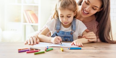 Holčička si s maminkou kreslí u stolu