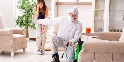 Deratizátor v obleku vysává před pohovkou