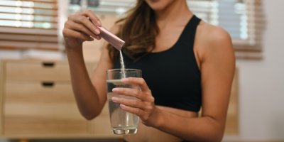 Žena si sype prášek do vody