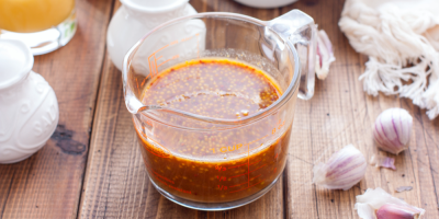 Medová hořčičná marináda v průhledné sklenici na dřevěném stole