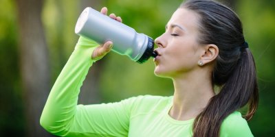 Mladá žena pije vodu z lahve