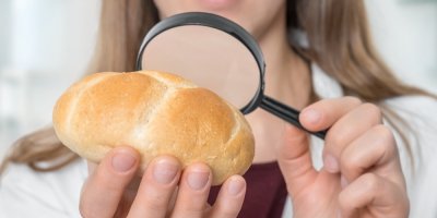 Žena zkoumá housku pod lupou