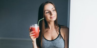 Žena pije proteinový drink po cvičení