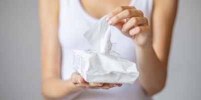 Žena vytahuje vlhčený ubrousek z balení