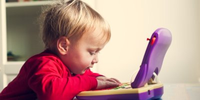 Malé dítě si hraje s dětským počítačem