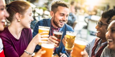 Mladí lidé pijí pivo a usmívají se