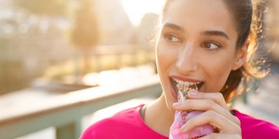 Mladá žena jí proteinovou tyčinku