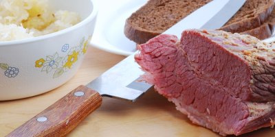 Hovězí hrudí, z něhož je odkrojený jeden plátek. Vedle miska s kysaným zelím