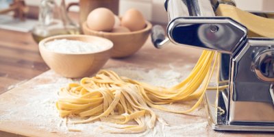 Čerstvě vyrobené dlouhé těstoviny u ručního těstovinového strojku