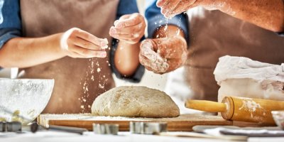 Dva lidé připravují těsto na chleba