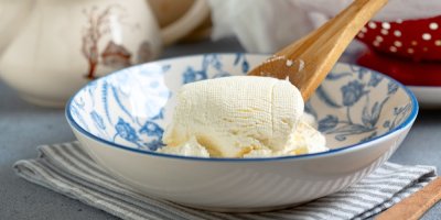 Domácí sýr v modro-bílé zdobené misce s vařečkou